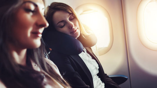 two women on a plane seated next to one another and sleeping